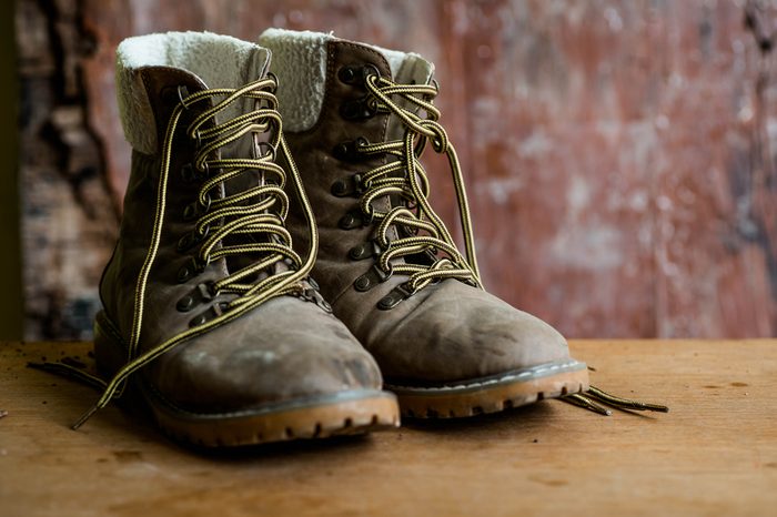 A pair of dirty boot on wooden background