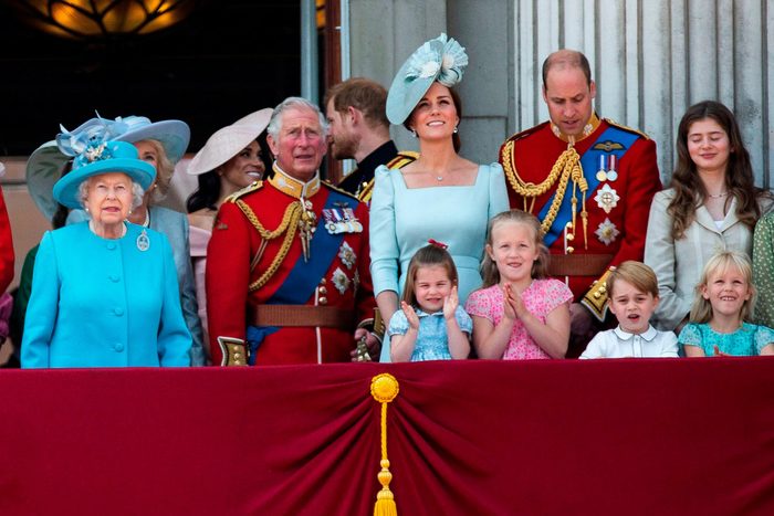 the royal family standing together outside of the palace