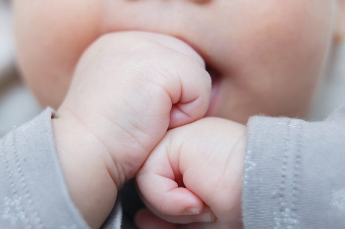 Baby hands. The child sucks fists