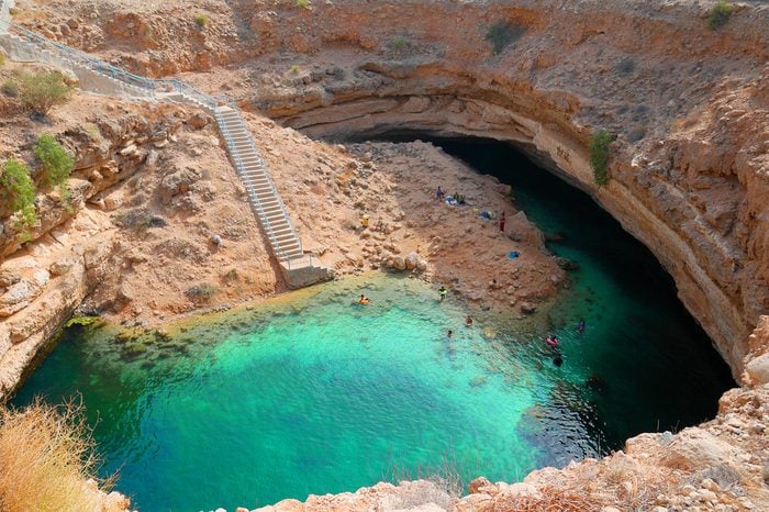 Bimmah sinkhole, one of the world most beautiful natural sinkhole in the Sultanate of Oman. Tourists can swim in the clear turquoise waters to cool off from the desert's heat from the nearby Wahiba