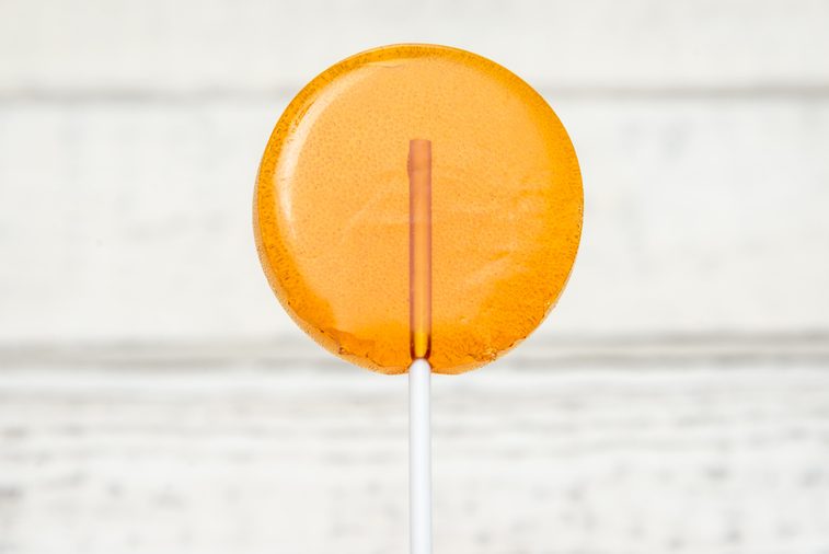 Orange candy, sweet candy on a stick, caramel