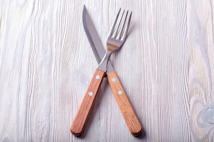 Knife and fork crossed. Knife and fork with wood handle