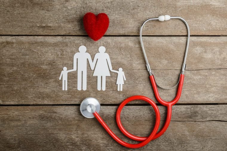 Red heart, stethoscope and paper chain family on wooden table, Health Insurance Concepts