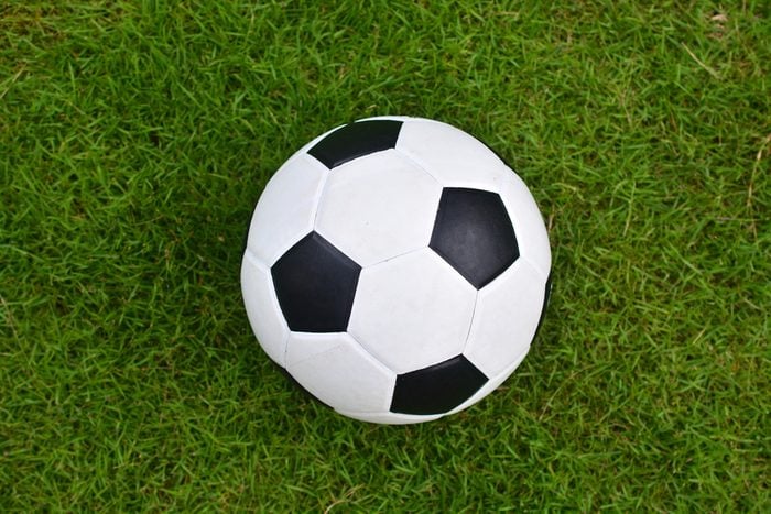 Soccer football on green grass field, Top view