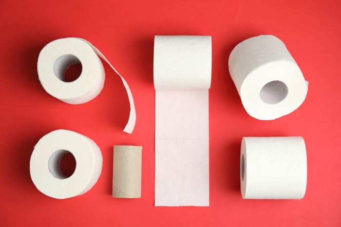 Flat lay composition with toilet paper rolls on color background