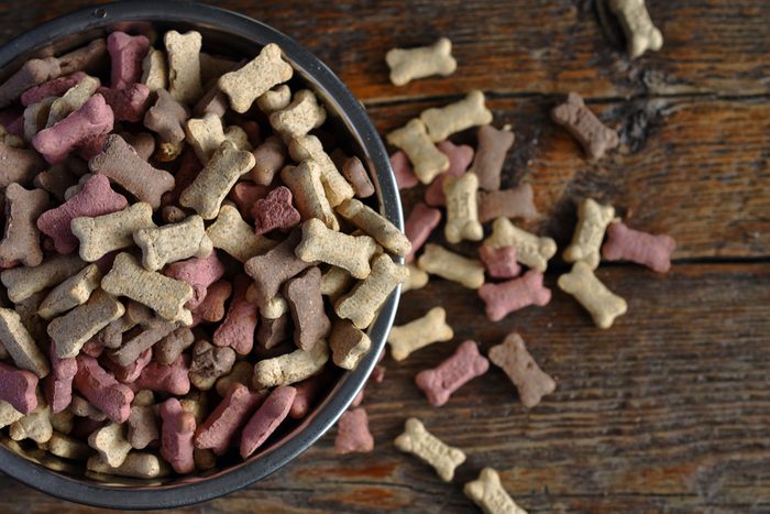 A top view image of small dog treats in a metal dog dish. 