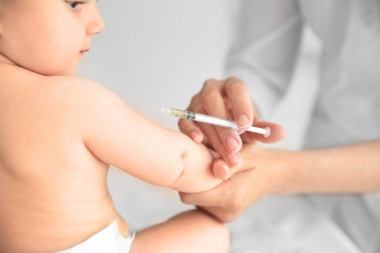 Professional pediatrician vaccinating baby, close up