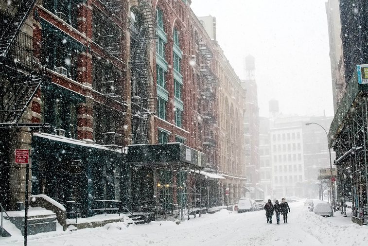 Friends travel down a New York City street in a blizzard