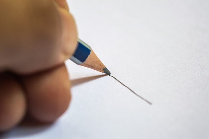 A person drawing a line with a pencil on a white background