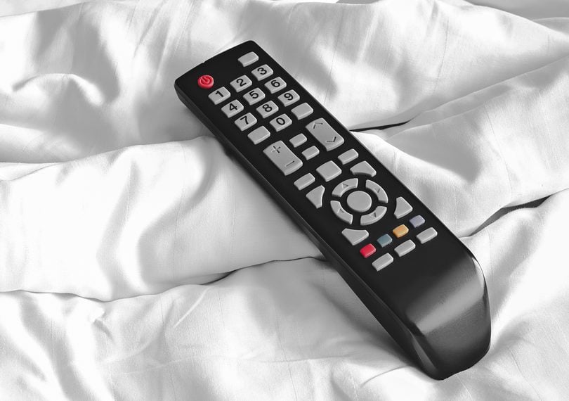 remote television on white bed sheets