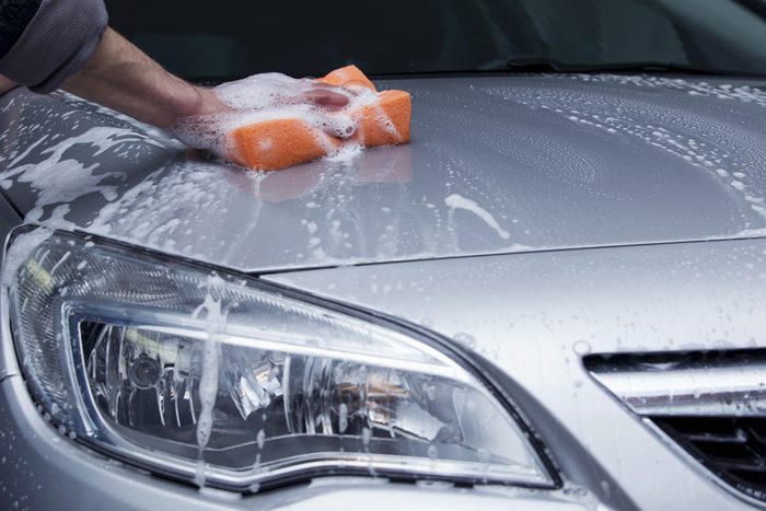 a silver car is washing in soap suds
