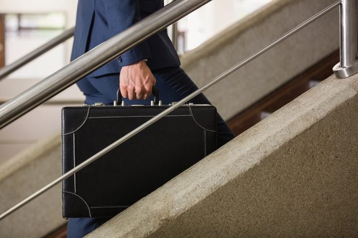 Businessman climbing up the stairs in office building