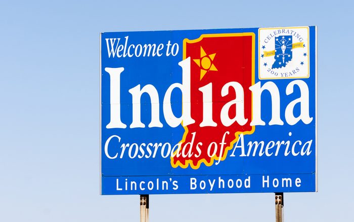 Blue sign against blue sky welcomes you to Indiana