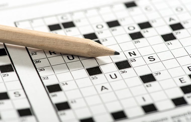 Conceptual Sharpened Pencil on Top of Crossword Puzzle Game Paper in Close up Shot