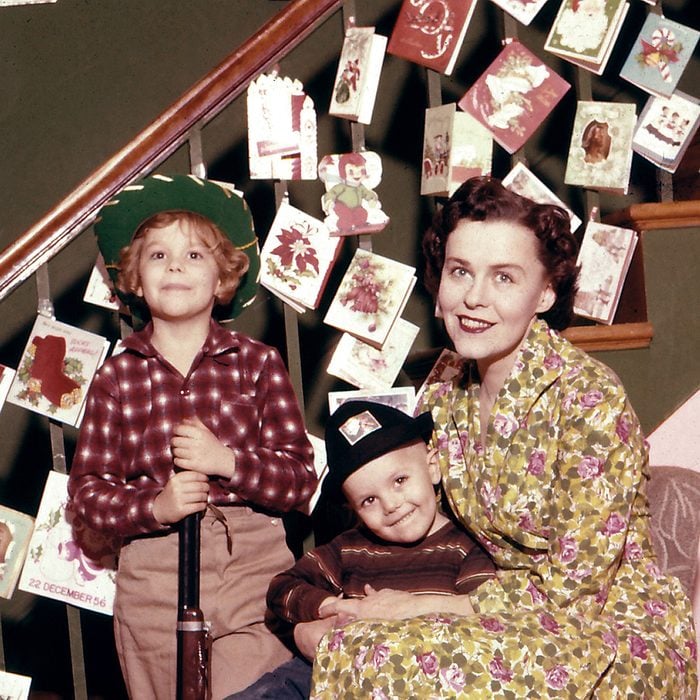 Mother with two sons in front of a decorated staircase