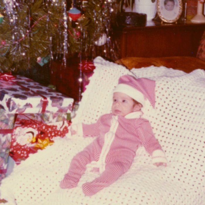 Baby laid out in front of the Christmas tree