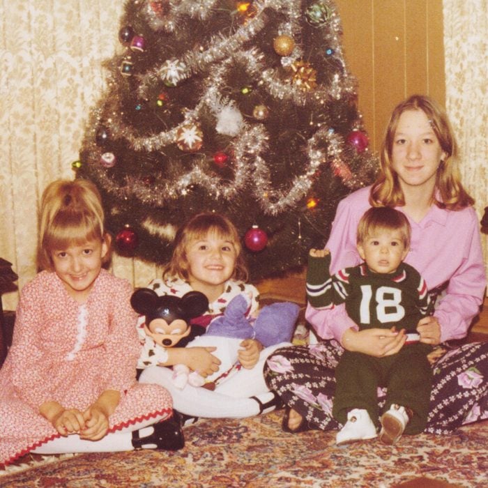 Mother and three small children in front of the Christmas tree