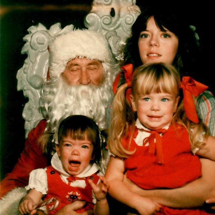 Mother and her two kids posing next to Santa