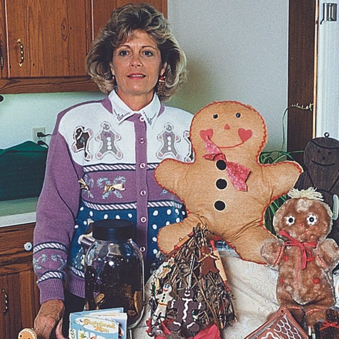 Woman standing proud next to her huge gingerbread creation