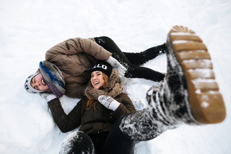 Winter. Cheerful young couple having fun in the snow. Winter love story.