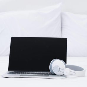 laptop and headphones on bed
