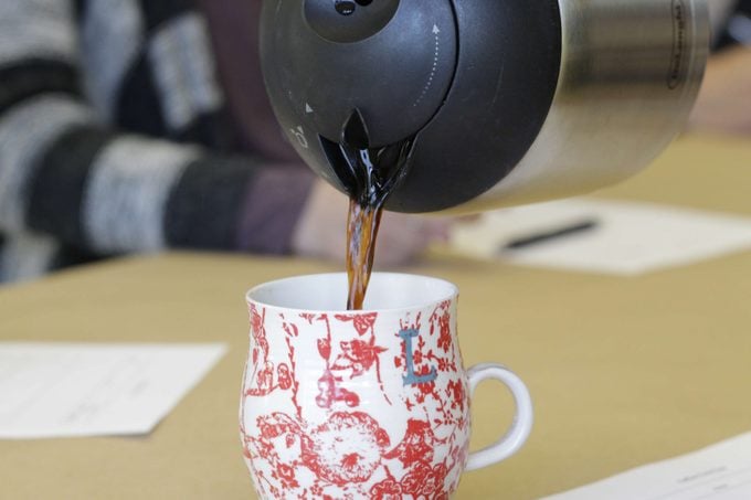 Coffee being poured into a red and white mug