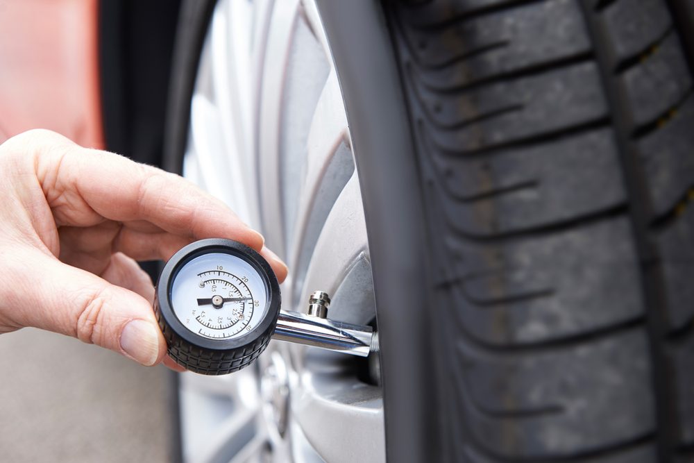  Man Checking Car Tire Pressure With Gauge