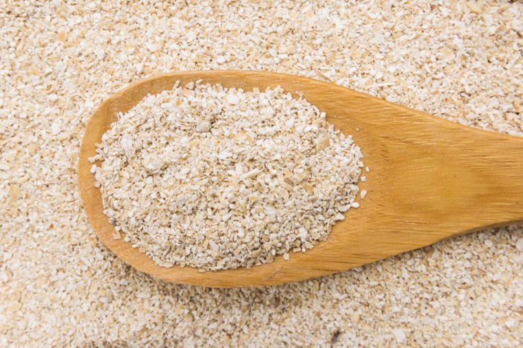 Avena Sativa is scientific name of Oat bran. Also known as Aveia or Avena. Grains in wooden spoon. Close up.