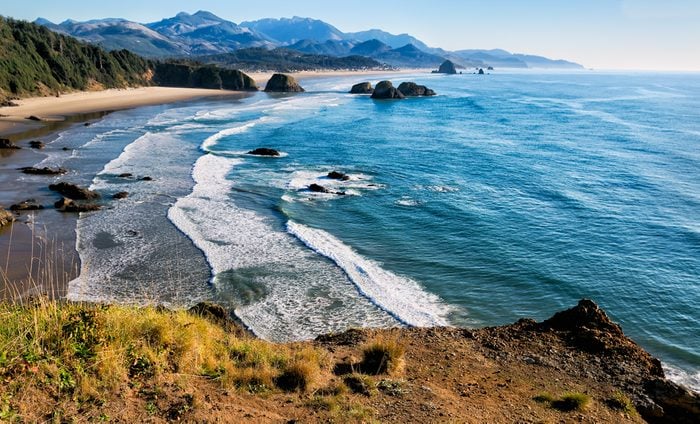 Sweeping view of the Oregon coast, miles of white sandy beaches, sea stacks and ocean waves. Location: Cliff's edge at Ecola Park overlook in the Pacific Northwest, USA