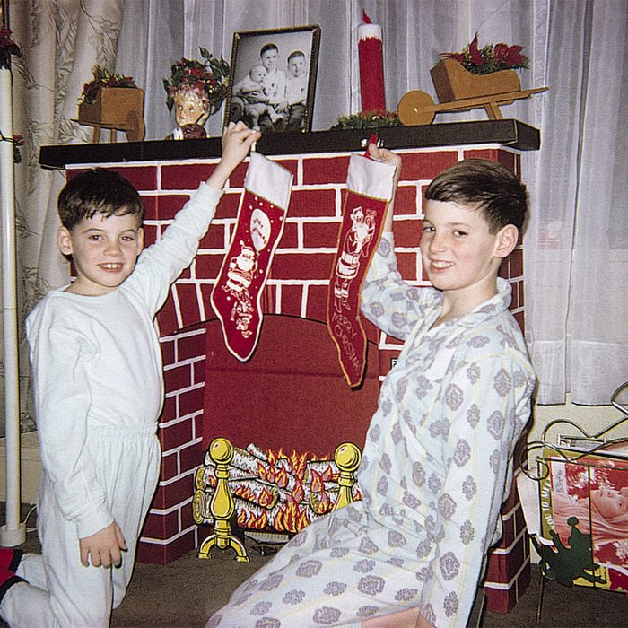 Boys holding stockings over fireplace
