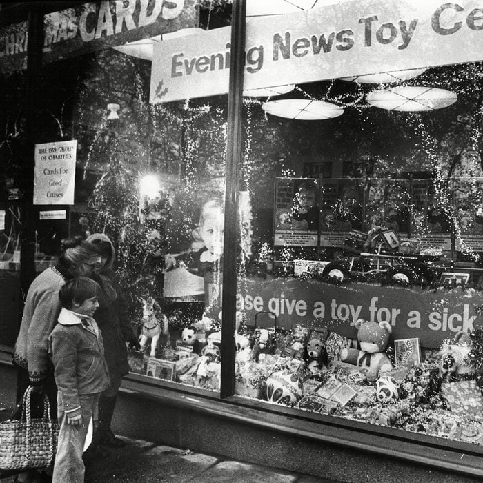 Shoppers Look In Store Window Display For Evening News's Toy For A Sick Child Campaign 1973.