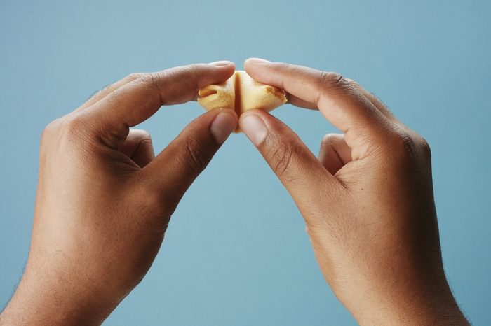 mixed race man's hand open a fortune cookies with an empty paper
