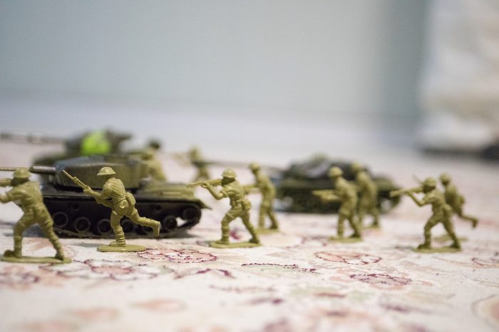 miniature toy soldiers and tank on board. Close up image of toy military at war. Selective focus
