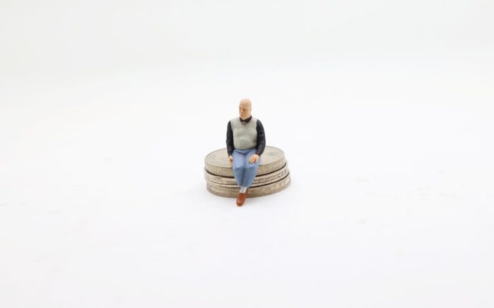 figure sitting on stack of coin , Money concepts.