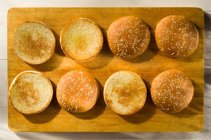 Burger buns with sesame seeds on a chopping board
