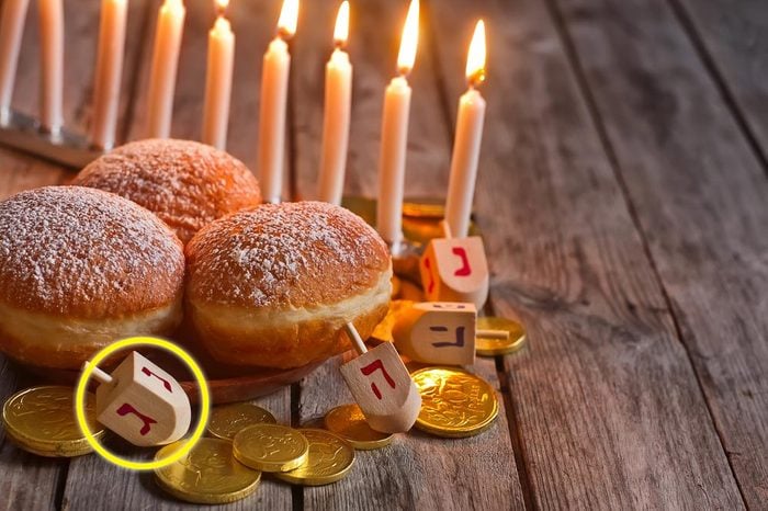 Jewish holiday hannukah symbols - menorah, doughnuts, chockolate coins and wooden dreidels. Copy space background.