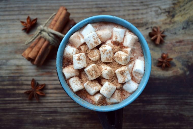 Black and blue cup of hot cocoa with marshmallows, star anise and cinnamon