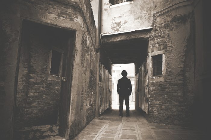 Man walking in a old mystic dark alley