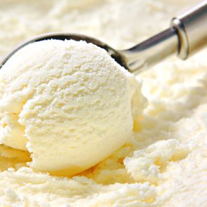 Vanilla ice cream scoop, scooped out of a container with a utensil