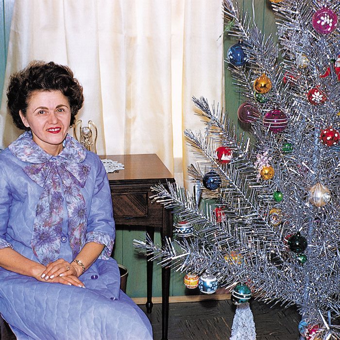 Older woman sitting beside a Christmas tree