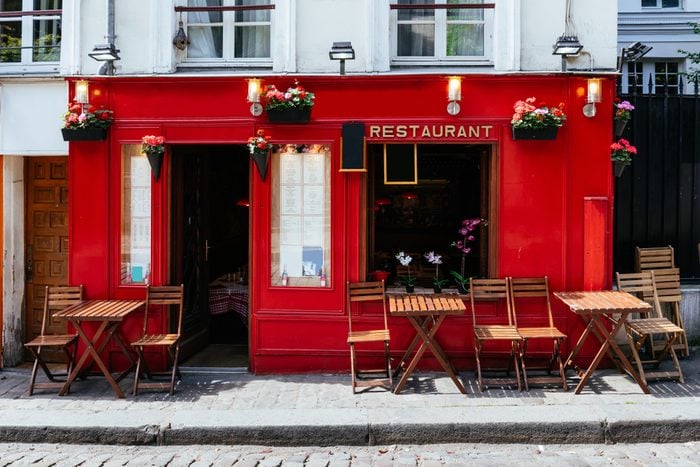 View of street with tables of cafe in quarter Montmartre in Paris, France. Cozy cityscape of Paris. Architecture and landmarks of Paris