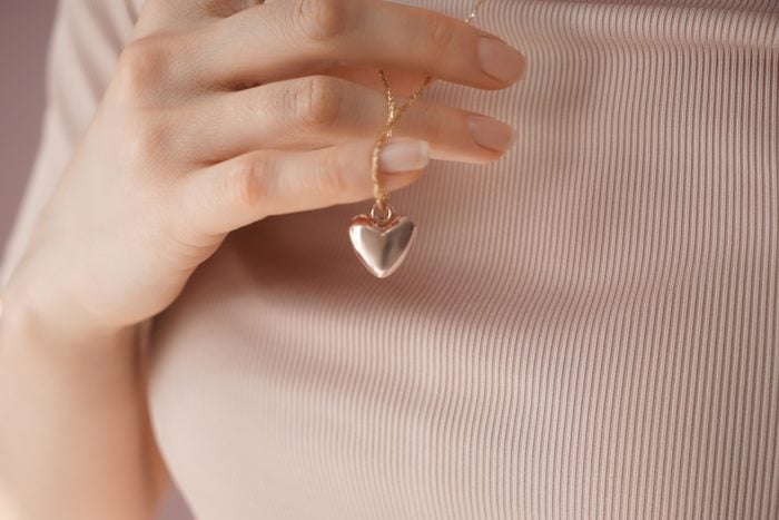 Woman wearing heart-shaped pendant, closeup