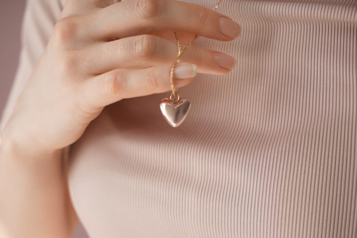 Woman wearing heart-shaped pendant, closeup