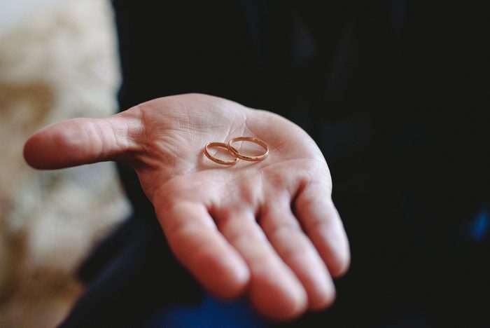 Simple gold wedding rings fastened in the palm of the groom's hand