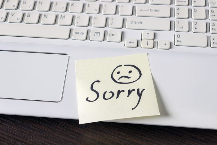 Handwritten note is on the keyboard. - Sorry. Sad smiley face drawn in black.