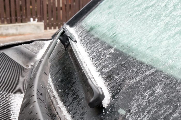 Frozen windshield wiper on car