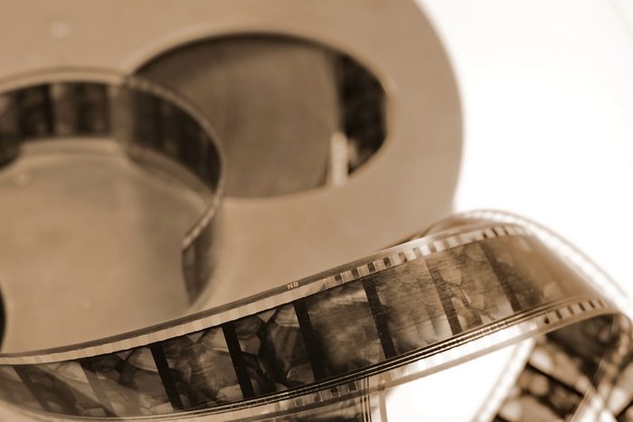 Old cine-film. Film strip on a blur background. Sepia photo.