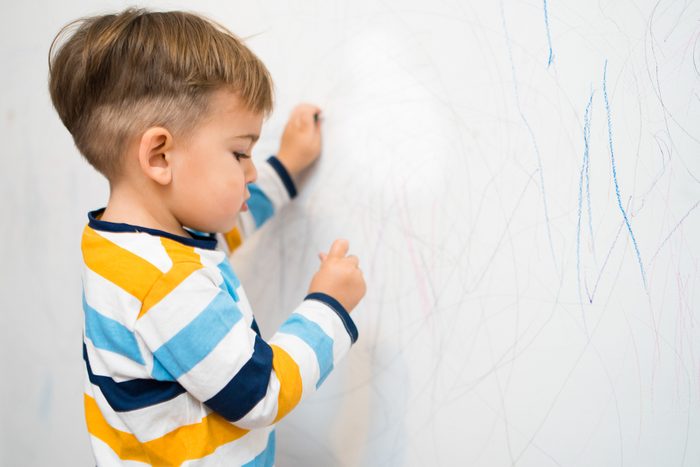 Little Boy drawing on the Wall
