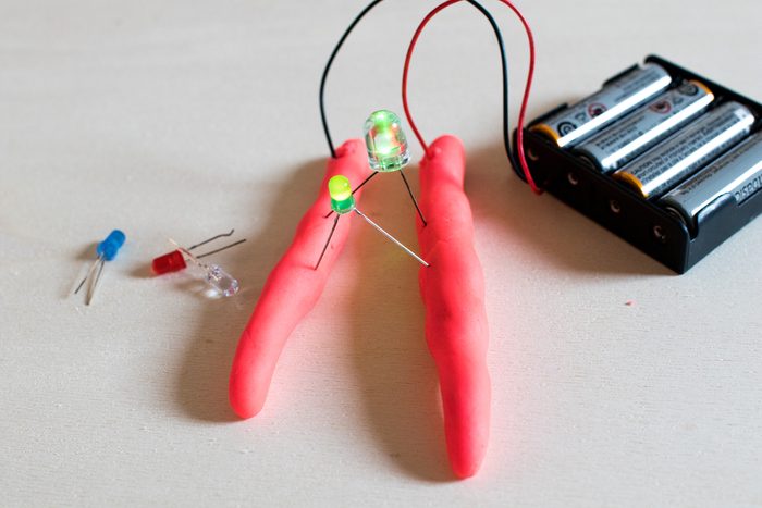 Electronic soft circuits with LEDs, batteries and modeling clay. Set for electronic education for children. Stem activity with green leds lights on