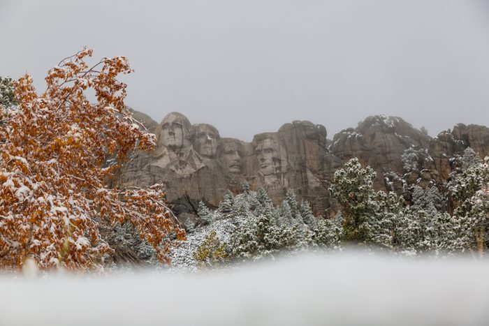 Iconic Mount Rushmore South Dakota showing the Presidents surrounded by snow. Capturing the amazing landscape scenery of the Black Hills coming into winter.